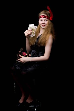 Fashionable little teen girl with a handbag in her hands. On a bの写真素材