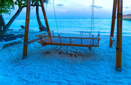 Exotic Tropical Paradise Swings over Crystal Clear Turquoise Bluの写真素材