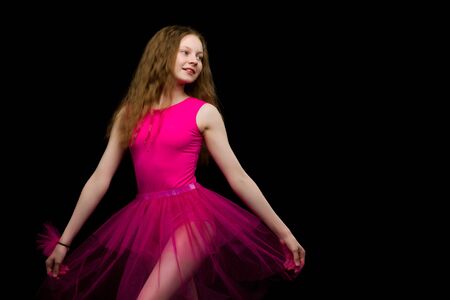 Girl gymnast in the studio on a black background performs gymnasの写真素材