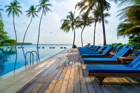 Lounge chairs on a beautiful tropical beach at Maldives