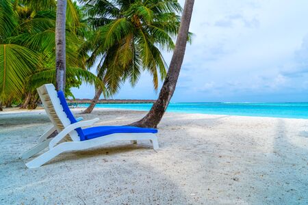 Lounge chairs on a beautiful tropical beach at Maldives