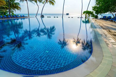 Private oceanfront pool with submerged loungers in a luxury resoの写真素材