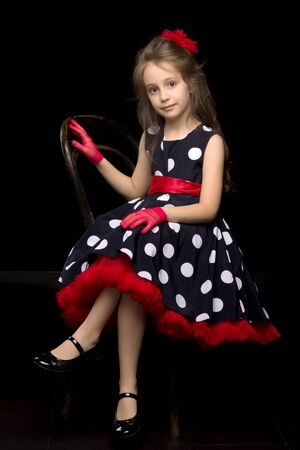 Portrait of Coquettish Girl Posing on Isolated Black Backgroundの写真素材