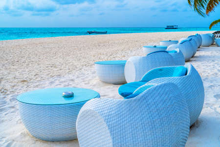 Beach chairs on the white sand on the shore of a beautiful tropical sea.の写真素材