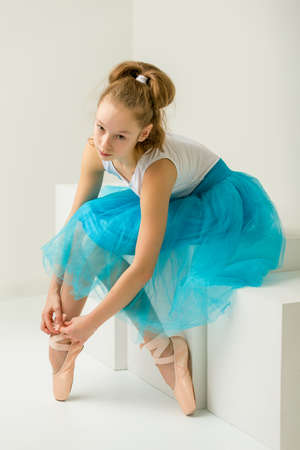 Girl ballerina puts on pointe shoes. The concept of dancing.の写真素材