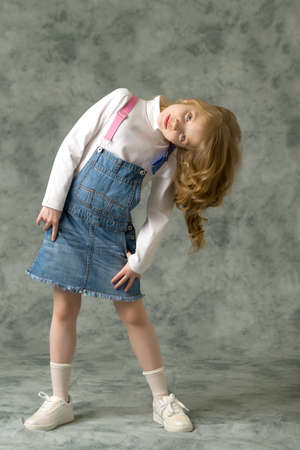 Little girl in a short denim dress.の写真素材