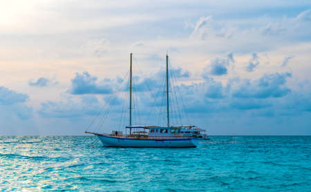 A pier in a tropical island. Yachts in a turquoise lagoon. Maldives holidayの写真素材