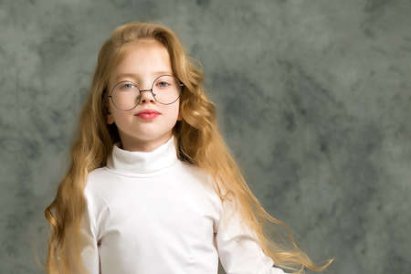Beautiful little girl in big round glasses.の写真素材
