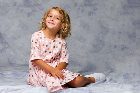 Little girl is sitting on the floor.The concept of a happy childhood.の写真素材