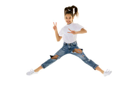 A little girl in a pure white t-shirt is jumping. The concept of advertising.の写真素材