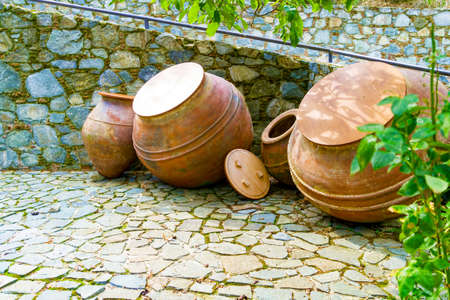 Stone Wall Made of Natural Rough Stones and Large Ceramic Amphoras