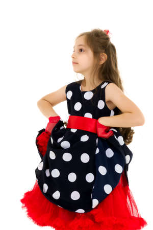 Charming girl in a blue polka dot dress with hands on the waist.の写真素材