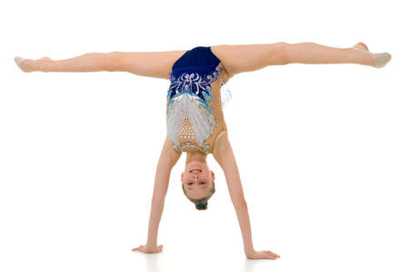 Beautiful girl gymnast performs a handstand.