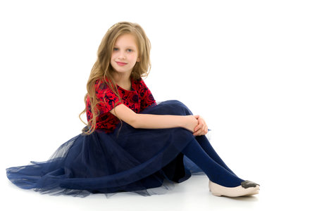 Blonde Girl in Stylish Tulle Dress Sitting on Floor Hugging her Kneesの写真素材