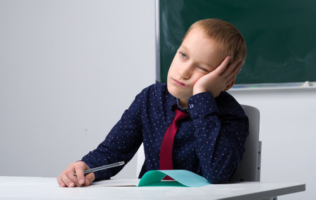 Thinking schoolboy studying at schoolの写真素材