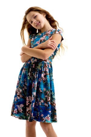 A beautiful little girl stands in the wind, her hair and clothes are developing greatly.の写真素材