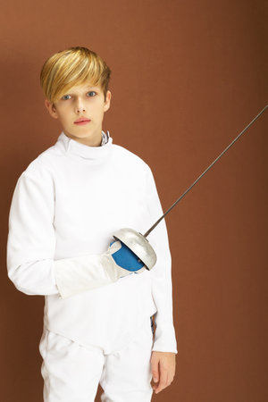 Boy fencer in white fencing costume with rapier