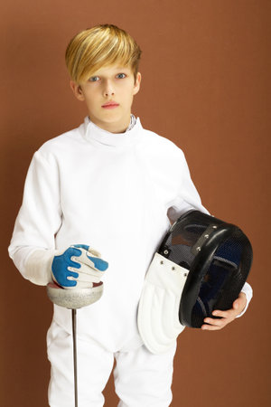 Boy fencer in white fencing costume with rapier