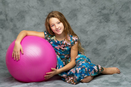 Little girl is playing with a ball.The concept of childrens sports, summer outdoor recreation.の写真素材
