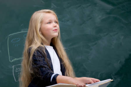 Happy schoolgirl sitting at deskの写真素材