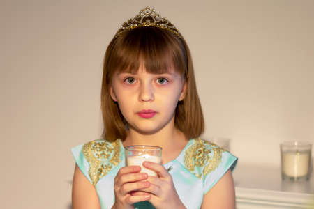 Cute little girl blowing on candles.の写真素材