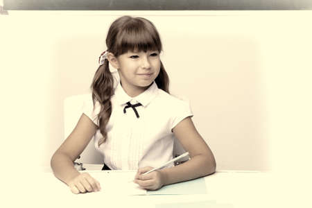 Girl thinking while sitting at desk at lesson