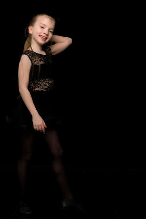 A beautiful little girl straightens her hair on her head.の写真素材