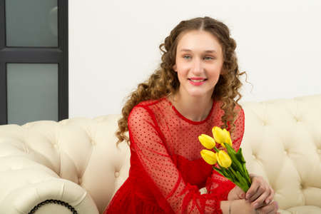 Portrait of pretty girl with fresh yellow tulips