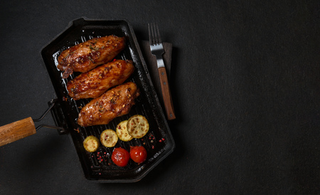 Chicken grilled on a grill pan.on dark texture bacgroundの写真素材