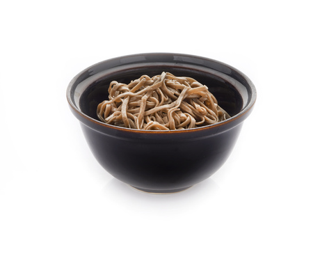Soba noodles on a black bowl. White background. Copy space.の写真素材