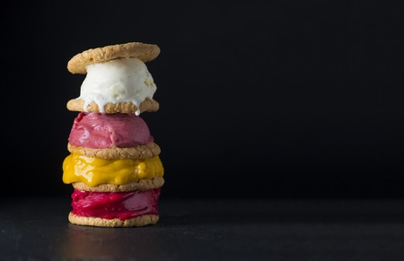 Stack of colorful ice cream with cookies on a black backgroundの写真素材
