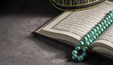 Islamic book Koran with rosary beads and pray hat for muslims on grey backgroundの写真素材