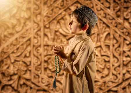 Little muslim boy with rosary beads praying to Godの写真素材