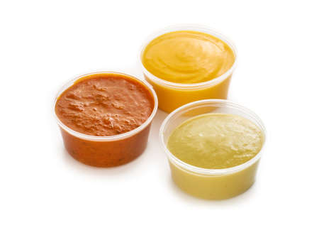 Plastic containers with sauces ketchup, mustard and cheese on white background, take away fast food...