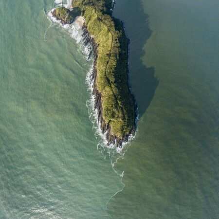 Bird's eye view of a cliff cape amid green seasの写真素材