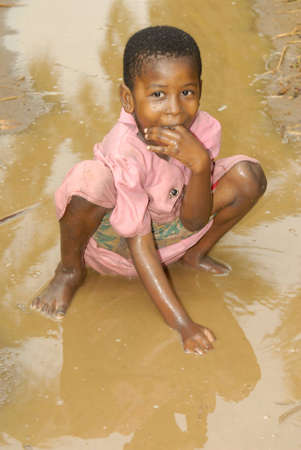 Young Swahili girl playing in the mud after the rain on Chole Mjini Island near Zanzibar Island, Tanzaniaのeditorial素材