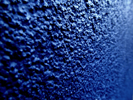 Macro close up of the pages of a book in black and white. Close up of the rough texture of a blue painted bumpy wall.の写真素材