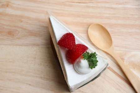 Strawberry layer cake with cream bakery fresh fruit topping individually wrapped. Put on the wooden tray and spoonの写真素材