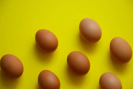 Fresh  group of poultry eggs uncooked  texture on yellow backgroundの写真素材
