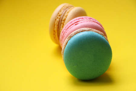 Selective focus at group of Macaroons pastels color snack and sweet food on yellow background