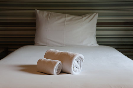 The single bed with towels rolls in the hotel bedroomの写真素材