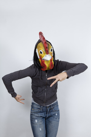 Woman wearing a cock mask and miming hip hop culture
She is wearing a hoody and a jeans with holesの写真素材