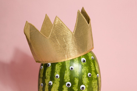 Freak watermelon wearing a crown on a pink backgroundの写真素材