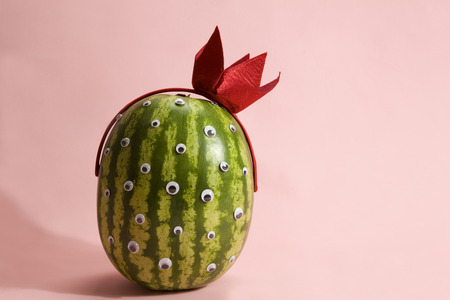 Freak watermelon wearing a crown on a pink backgroundの写真素材