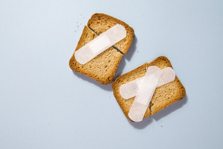 Repair a broken rusk with a plaster medical on a blue backgroundの写真素材