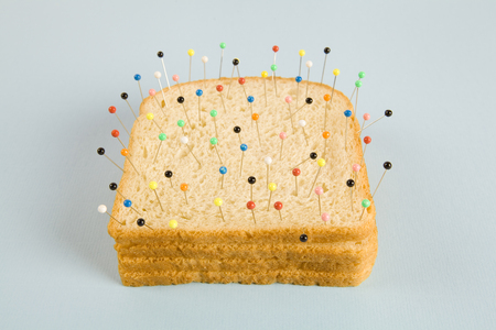 still life photography of a quirky soft bread stacked and used as a voodoo doll on a blue and...