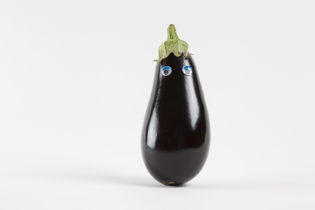 still life photography. Eggplant with eyes doll isolated on a white backgroundの写真素材