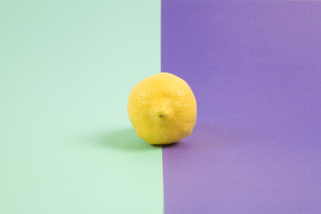 Pop minimal still life photography. lemon isolated on a Pop minimal still life photography. Lemon yellow isolated on a purple background bicolor purple and turquoise backgroundの写真素材