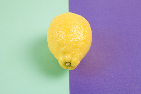 Pop minimal still life photography. lemon isolated on a Pop minimal still life photography. Lemon yellow isolated on a purple background bicolor purple and turquoise backgroundの写真素材