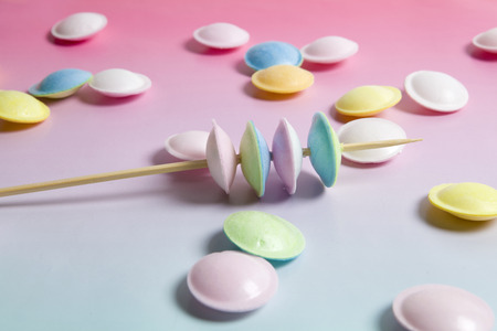 flying saucer multi coloured candy sweets on a gradient background pink and blue.
Minimal color still life photographyの写真素材